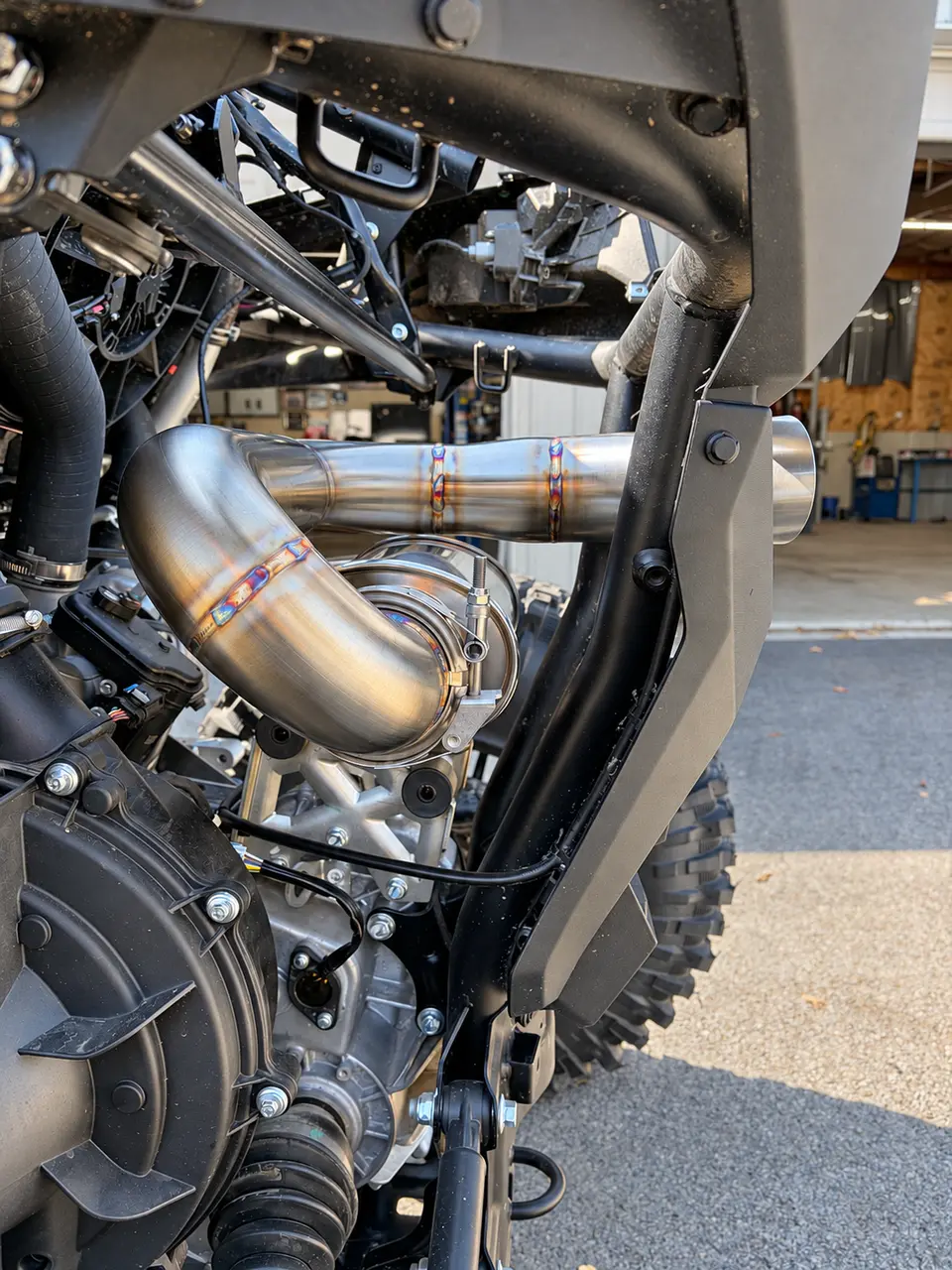 The details deserve a closer look. See the JKBuilt RECOIL’s welded bends, polished finish, and clamp connection up close beneath the rear bodywork.